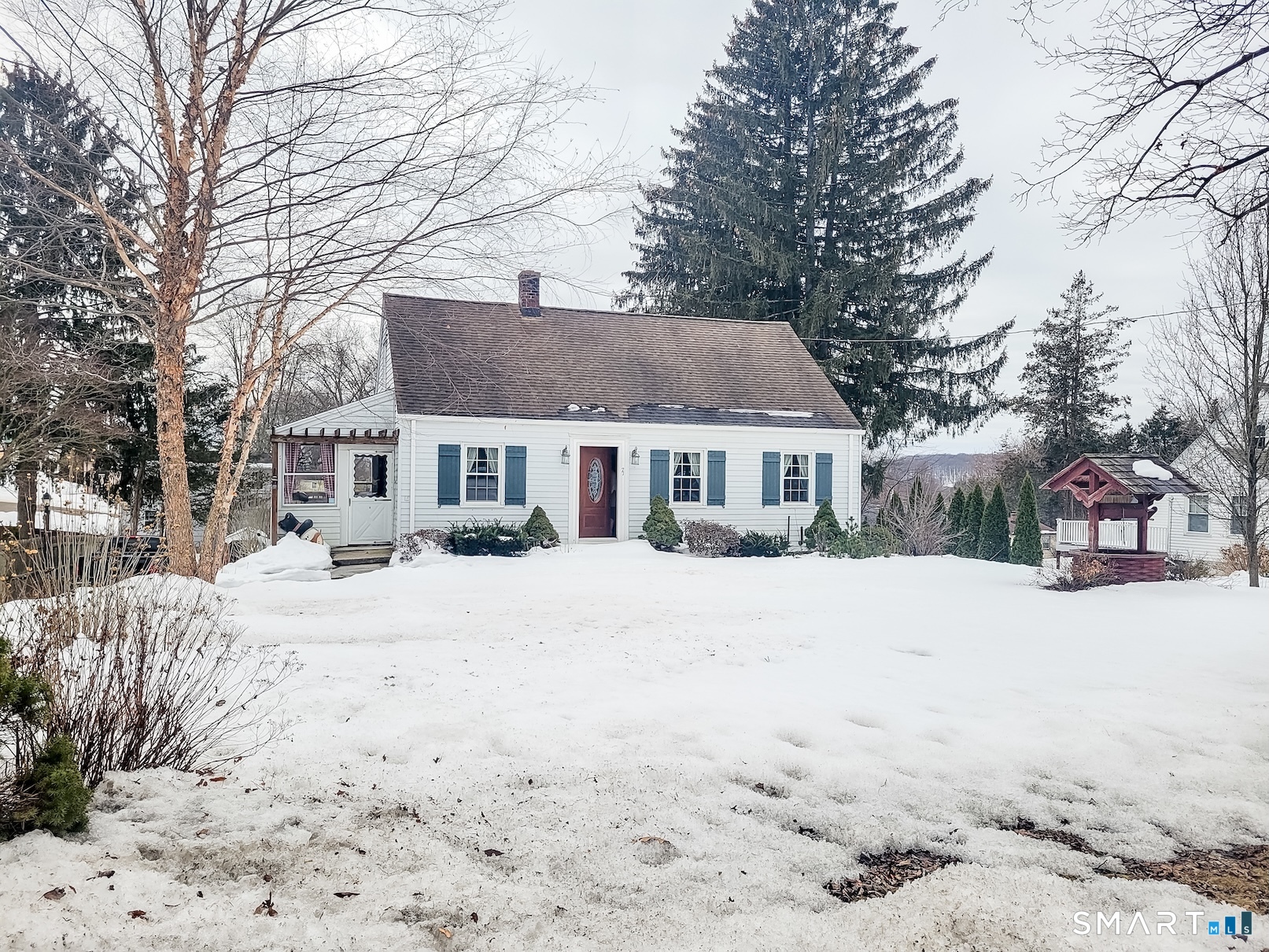 a front view of a house with a yard covered in snow