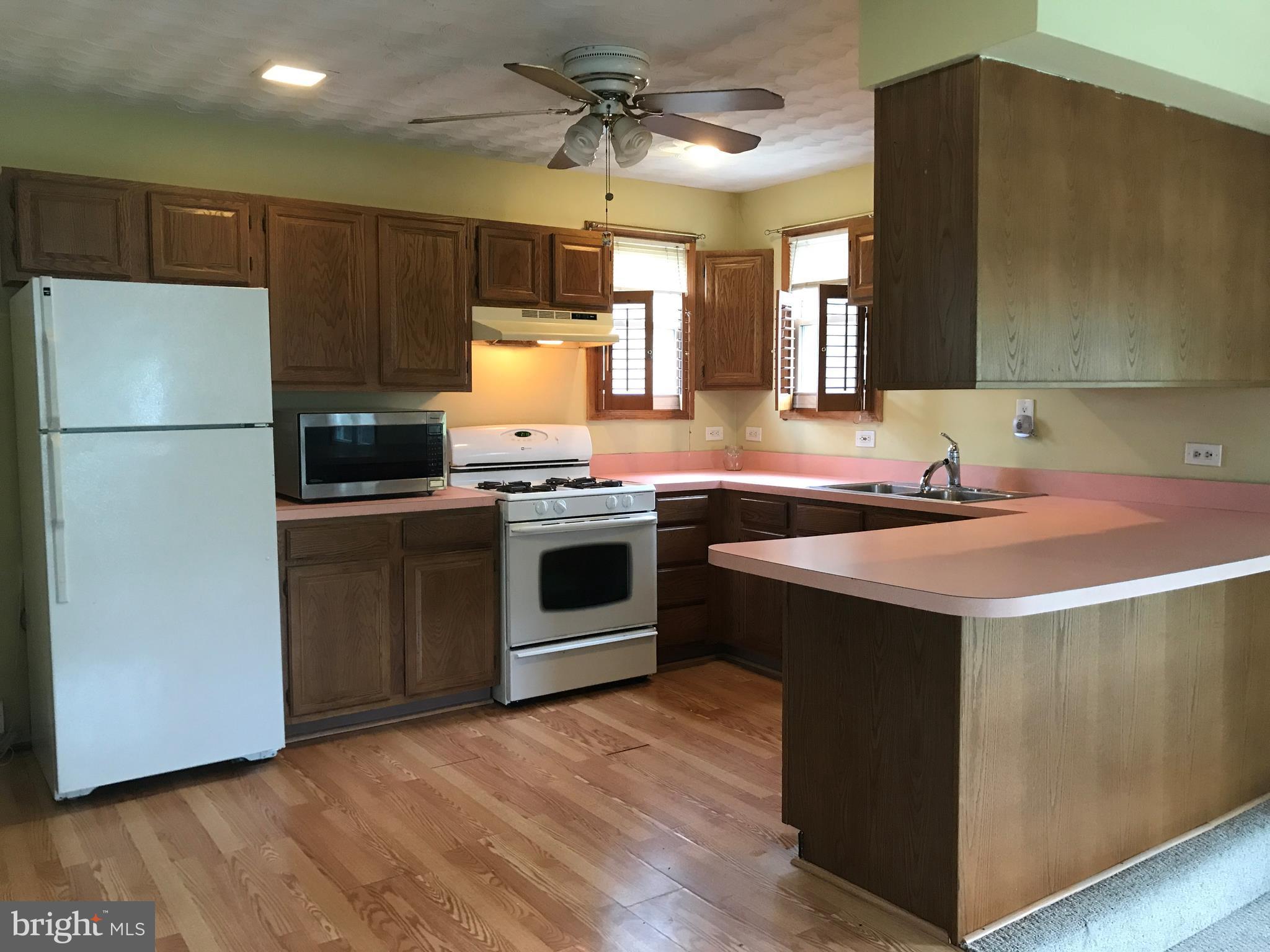 8 Crafton Road Baltimore, MD 21221 - Photo 14 of 30 a kitchen with a sink a stove a refrigerator and cabinets