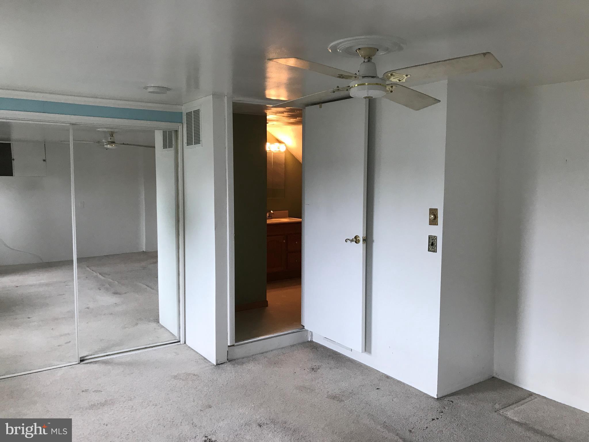 8 Crafton Road Baltimore, MD 21221 - Photo 22 of 30 an empty room with a mirror and a fan