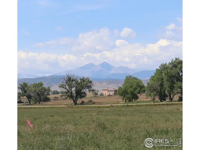 a view of a green field with wooden fence