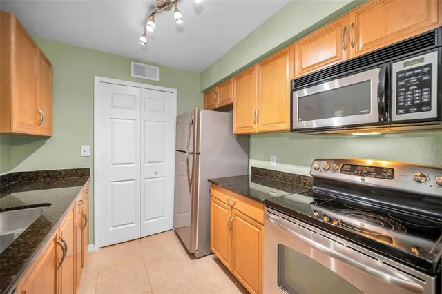 a kitchen with stainless steel appliances granite countertop a refrigerator and a stove top oven