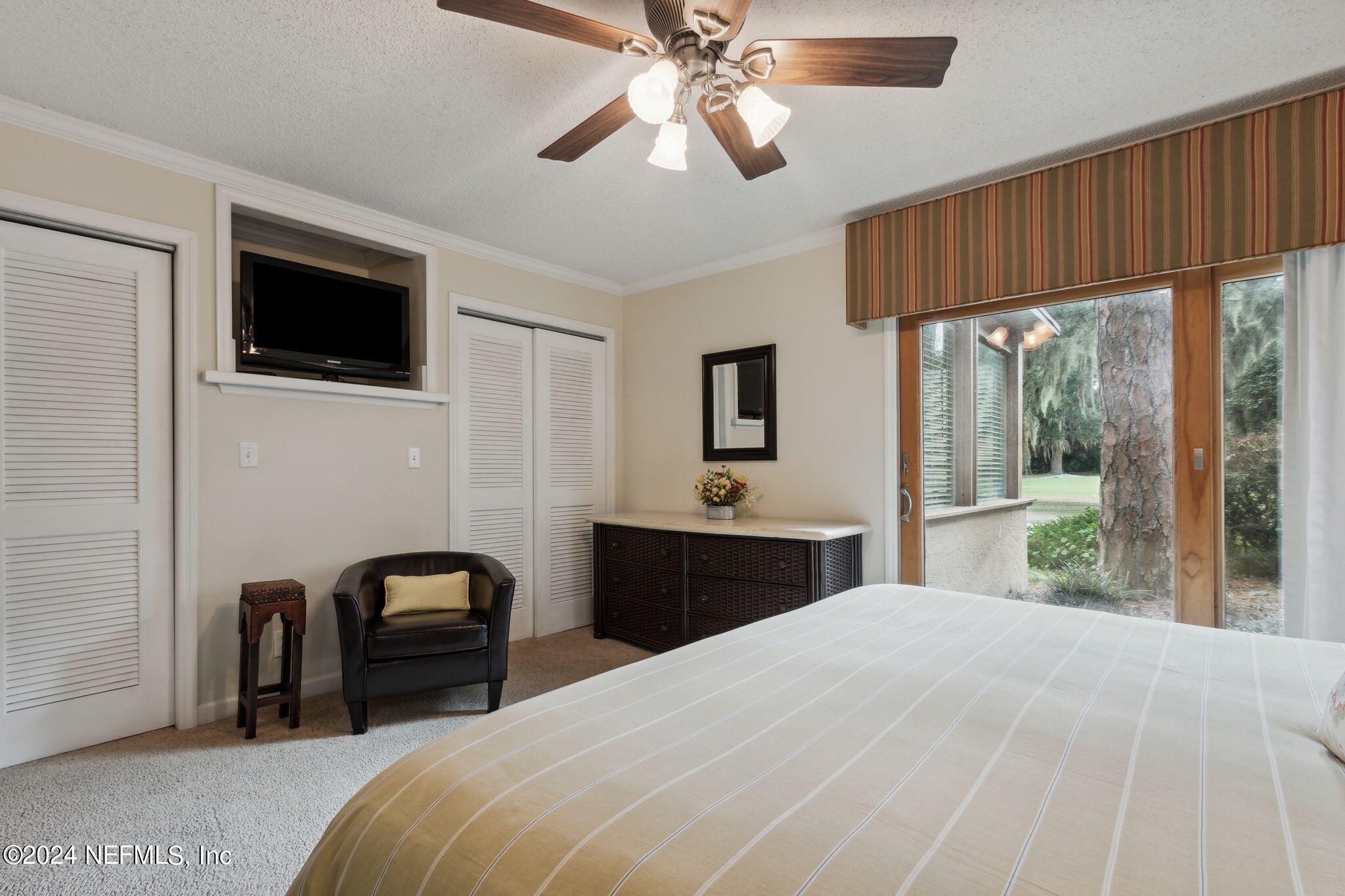 3327 Sea Marsh Road Fernandina Beach, FL 32034 - Photo 18 of 39 a bedroom with a large bed and a flat screen tv