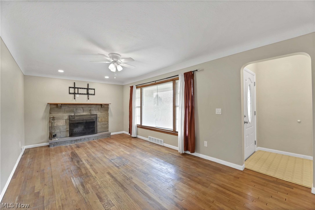 7528 State Road Parma, OH 44129 - Photo 6 of 40 Unfurnished living room featuring dark hardwood / wood-style flooring, ceiling fan, and a fireplace