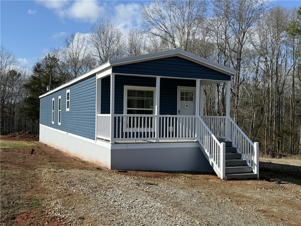This cozy residence offers a welcoming front porch, perfect for enjoying peaceful surroundings.
