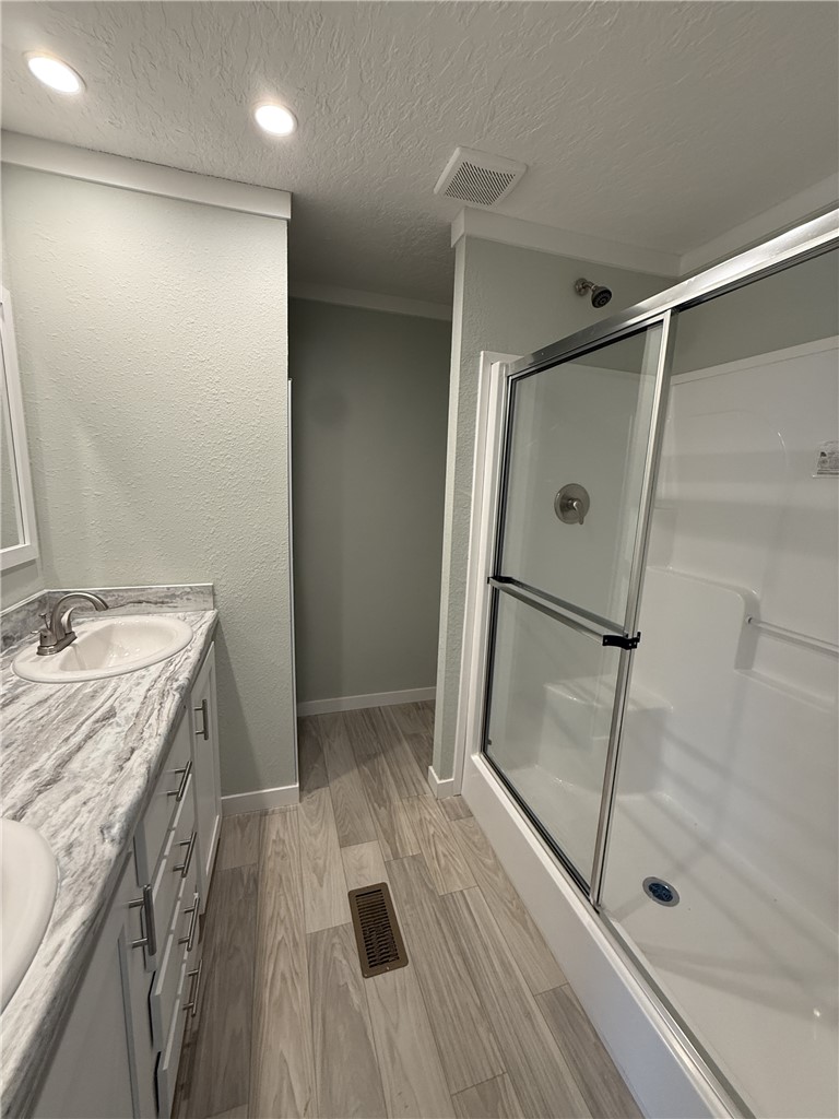 121 Candlestick Lane Seneca, SC 29678 - Photo 11 of 17 This bathroom features a double vanity and a shower with sliding glass doors, creating a serene and functional space.