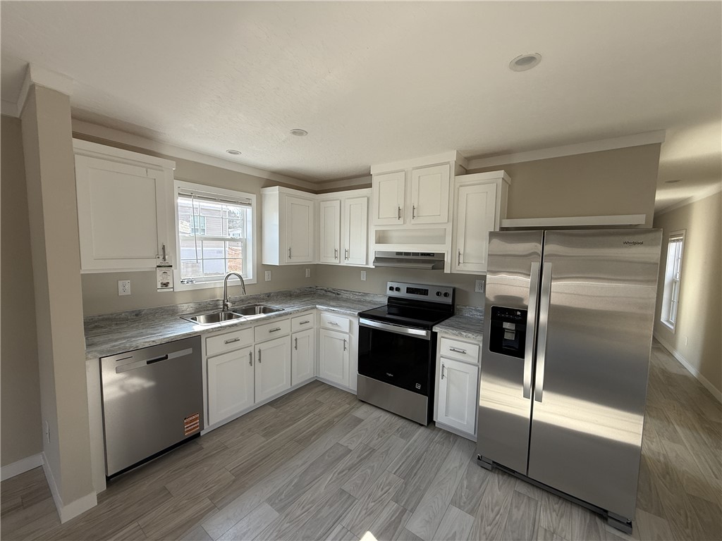 121 Candlestick Lane Seneca, SC 29678 - Photo 8 of 17 This bright kitchen features modern appliances, white cabinetry, and durable tile flooring.