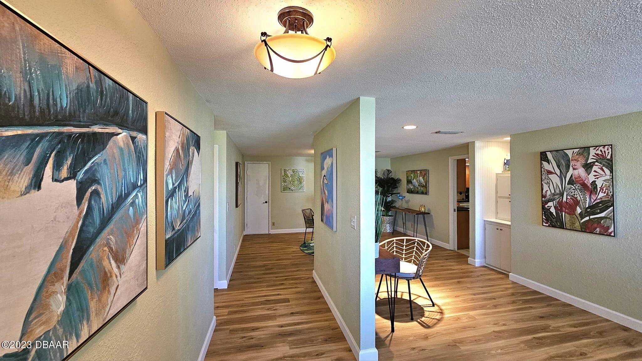 6 Sunrise Avenue Ormond Beach, FL 32176 - Photo 29 of 83 a view of a hallway with wooden floor and chandelier
