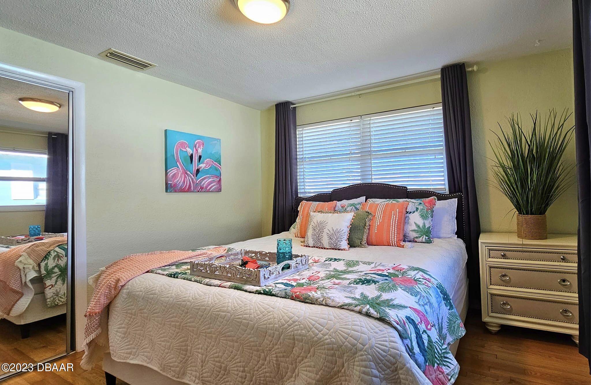 6 Sunrise Avenue Ormond Beach, FL 32176 - Photo 54 of 83 a bedroom with a bed a dresser and potted plants