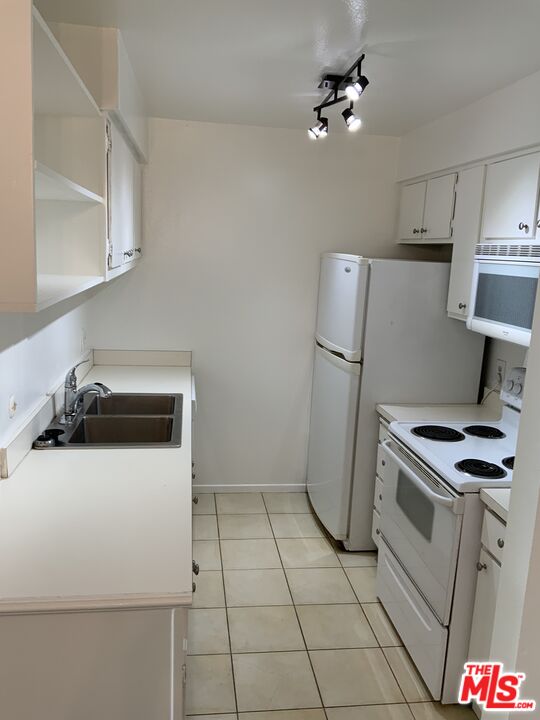 3205 Raintree Circle Culver City, CA 90230 - Photo 8 of 14 a kitchen with a stove a refrigerator and white cabinets