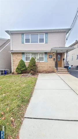 a front view of a house with a yard and potted plants