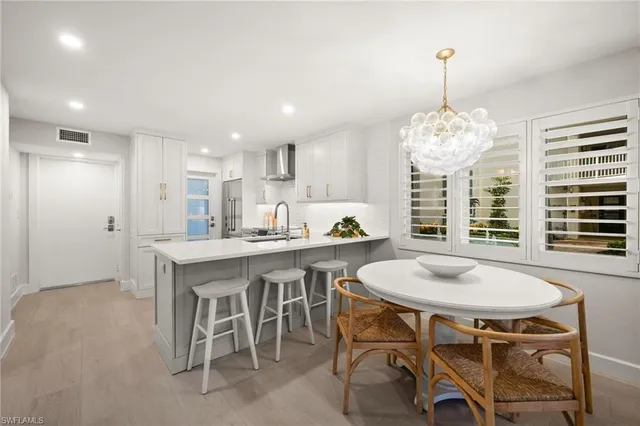 a kitchen with kitchen island a table and chairs in it