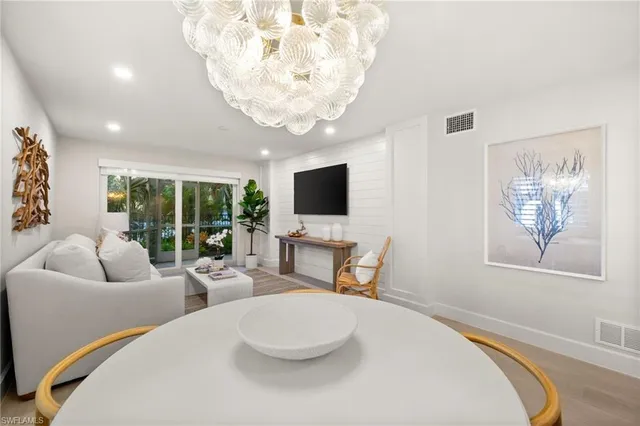 a living room with furniture a flat screen tv and a large window