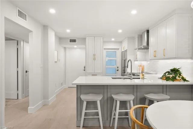 a kitchen with kitchen island cabinets and chairs in it