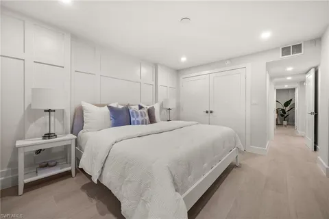 a spacious bedroom with a bed and a lamp