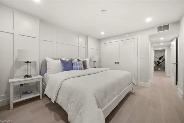 a spacious bedroom with a bed and a lamp