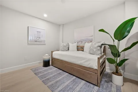 a bedroom with a large bed and a potted plant