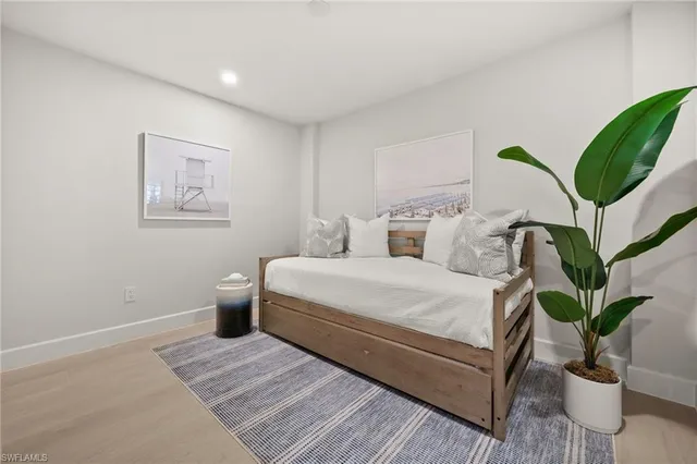 a bedroom with a large bed and a potted plant