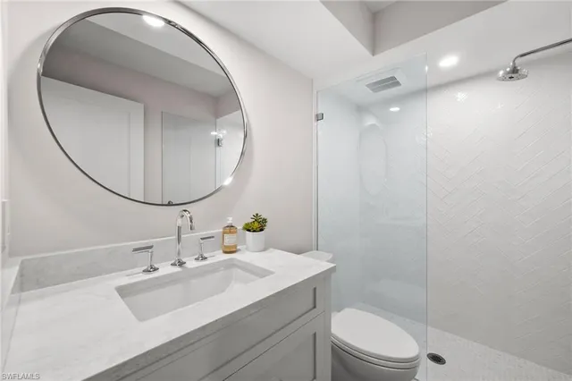a bathroom with a sink vanity mirror and toilet