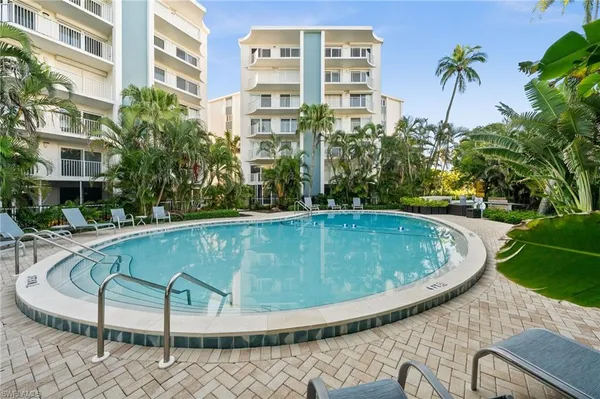 a swimming pool with outdoor seating and plants