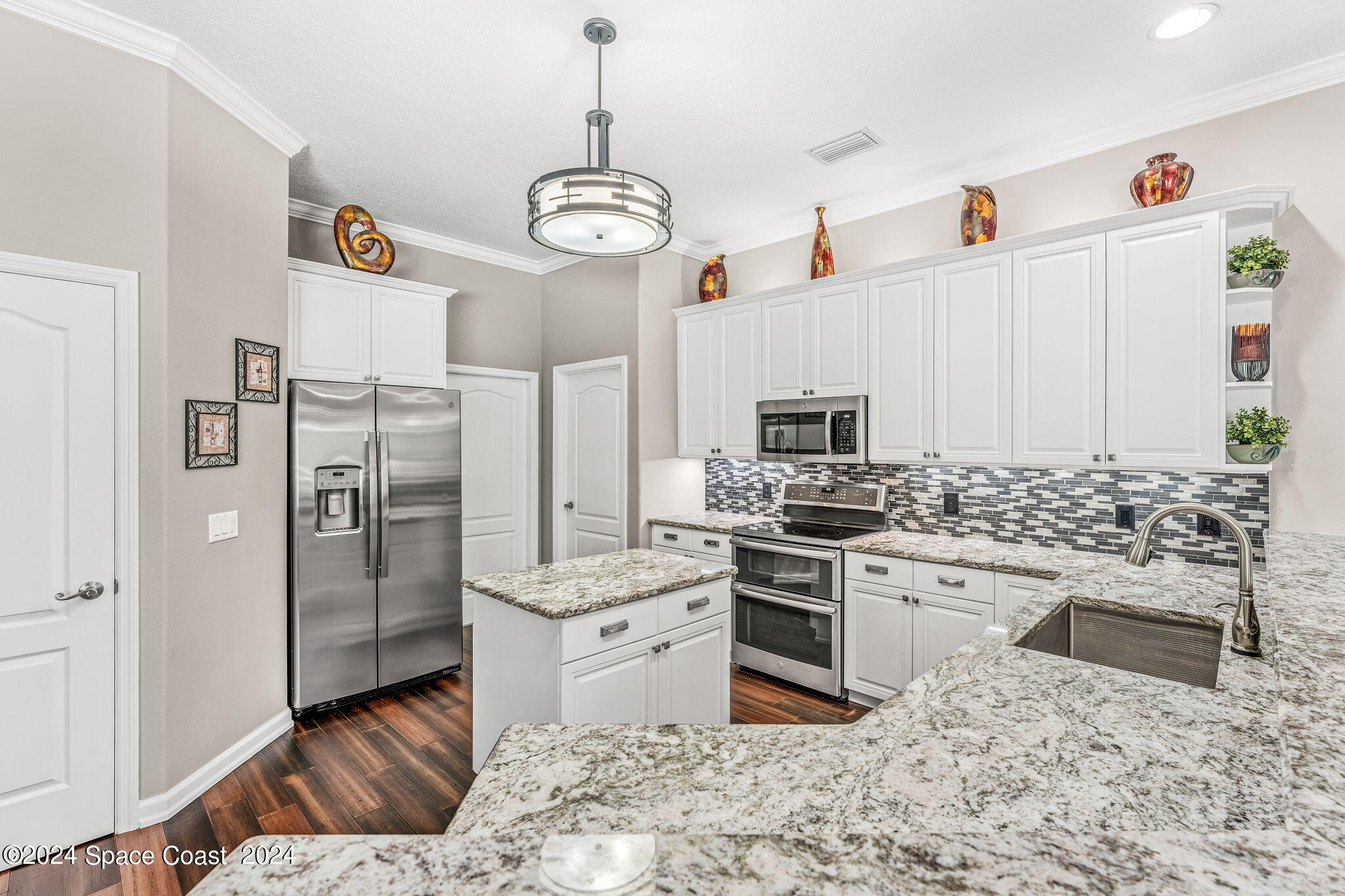 1633 Quinn Drive Rockledge, FL 32955 - Photo 11 of 50 a kitchen with stainless steel appliances granite countertop a stove top oven a refrigerator and a sink