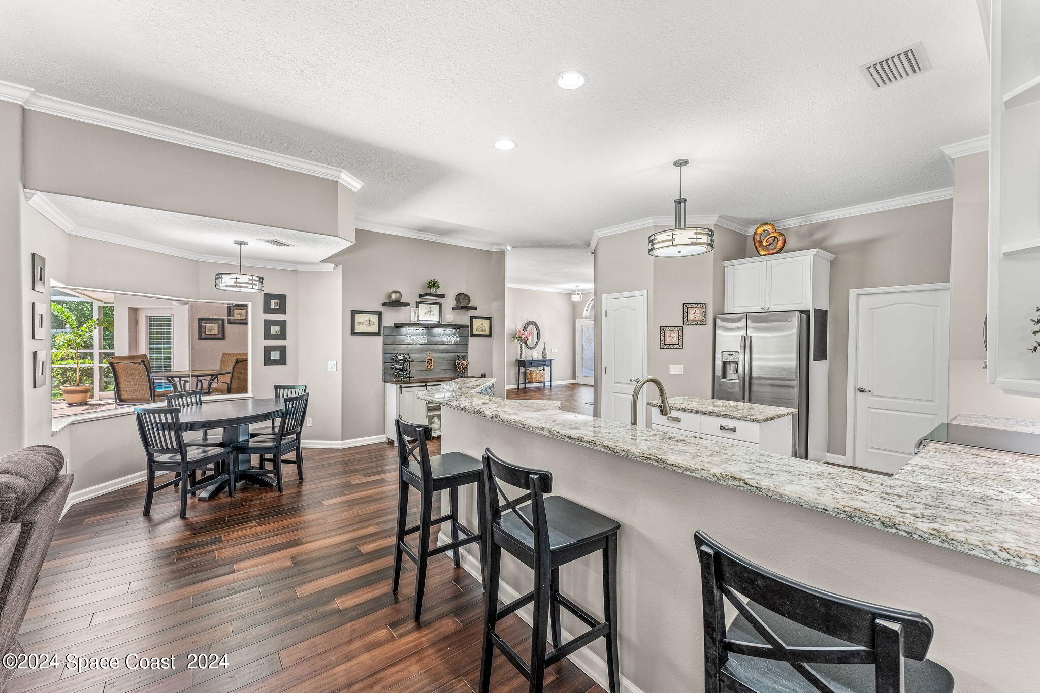 1633 Quinn Drive Rockledge, FL 32955 - Photo 12 of 50 a kitchen with granite countertop a table chairs stove and wooden floor