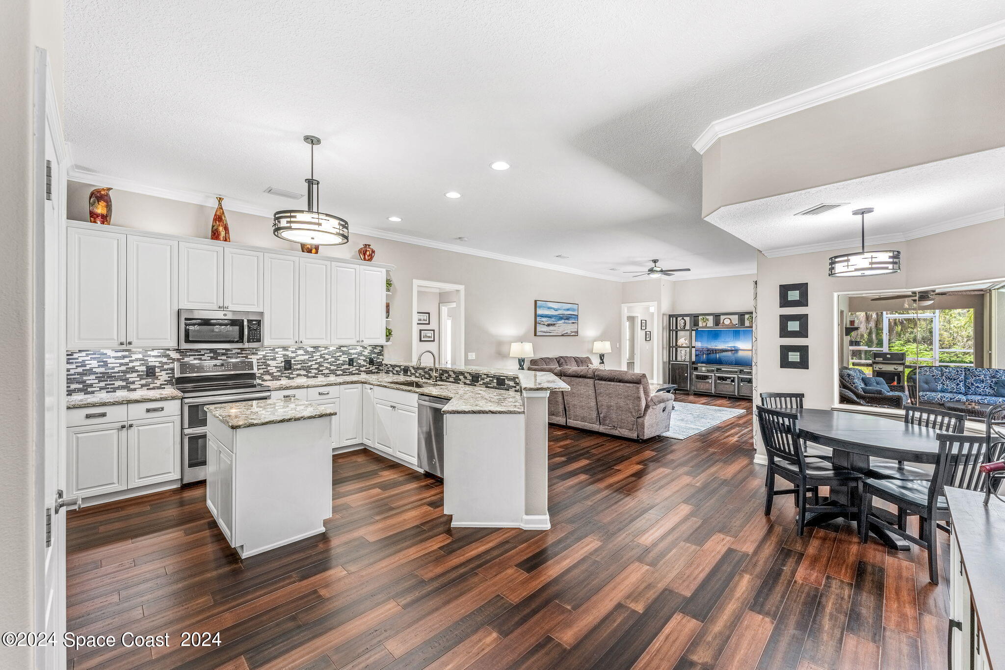 1633 Quinn Drive Rockledge, FL 32955 - Photo 13 of 50 a kitchen with stainless steel appliances a dining table chairs stove and cabinets