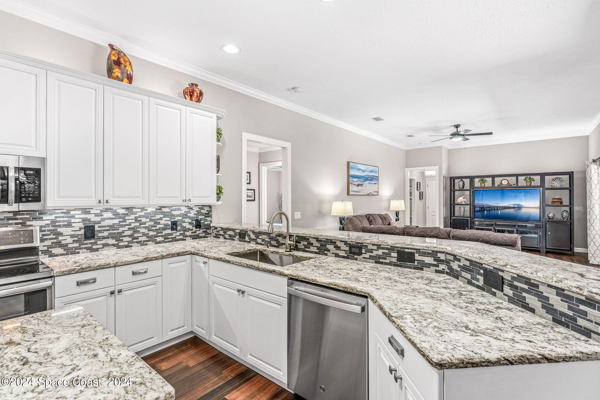1633 Quinn Drive Rockledge, FL 32955 - Photo 14 of 50 a kitchen with stainless steel appliances granite countertop a sink stove and cabinets