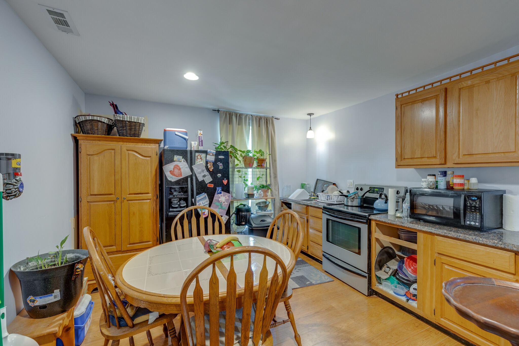 3003 Greens Mill Road Spring Hill, TN 37174 - Photo 24 of 48 a kitchen with stainless steel appliances granite countertop a sink a stove a dining table and chairs with wooden floor