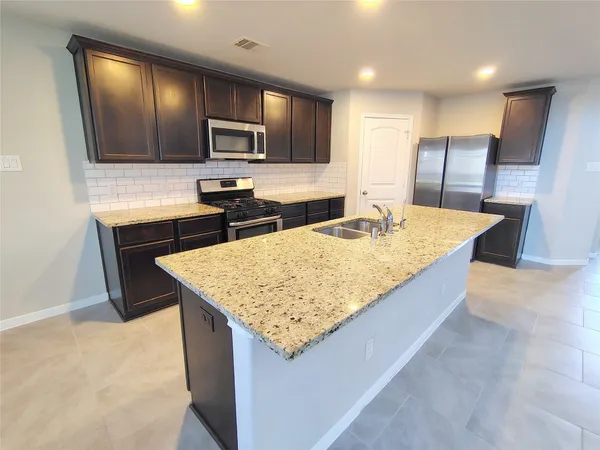 a kitchen with center island and stainless steel appliances