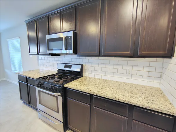 a kitchen with granite countertop stainless steel appliances and cabinets