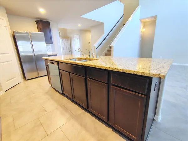 a kitchen with stainless steel appliances granite countertop a sink a stove and a refrigerator