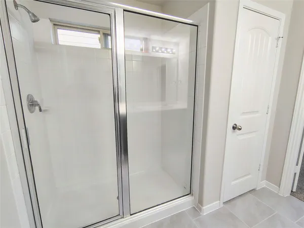 a bathroom with a glass shower door and sink