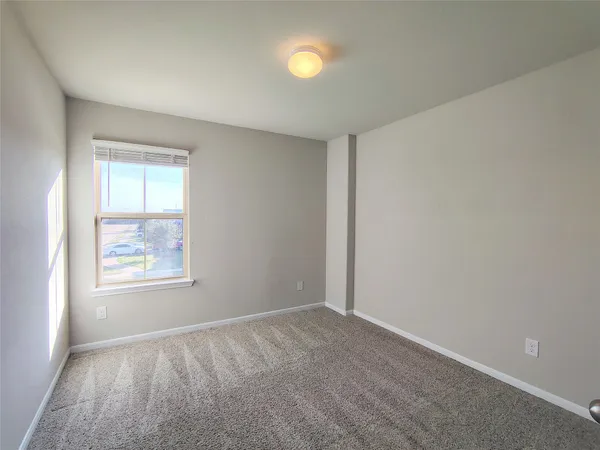 an empty room with windows and mirror fan