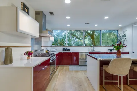 a kitchen with kitchen island granite countertop a sink and wooden cabinets