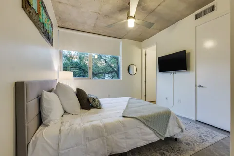 a bedroom with a bed and a flat screen tv