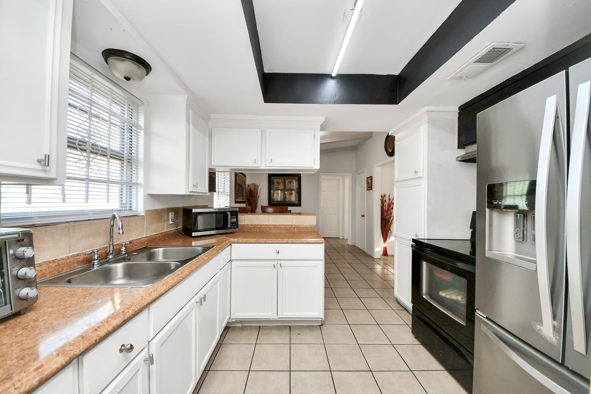 6319 Guadalupe Street Houston, TX 77016 - Photo 7 of 32 a kitchen with a sink stainless steel appliances and white cabinets