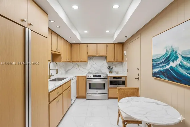 a kitchen with stainless steel appliances granite countertop a sink stove and refrigerator