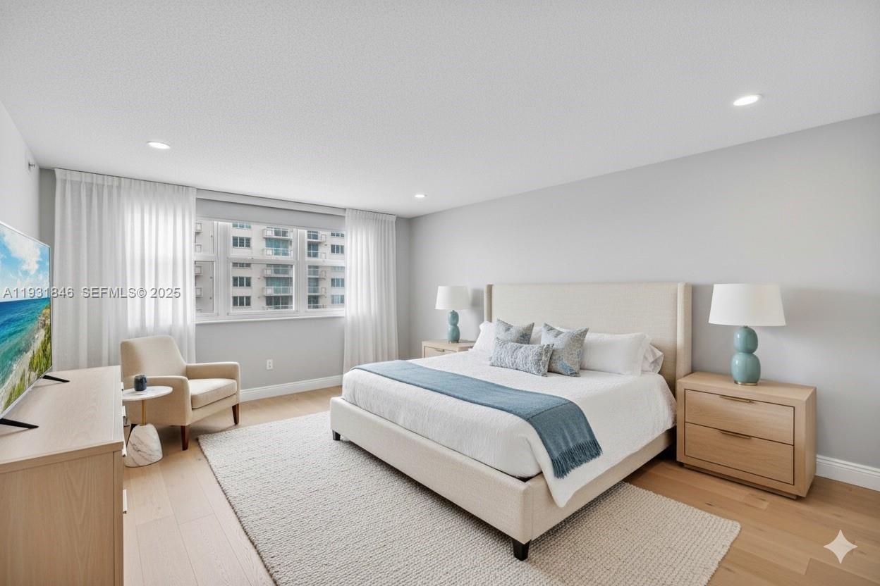 9511 Collins Avenue, Unit 606 Surfside, FL 33154 - Photo 15 of 43 a bedroom with a bed and a large window