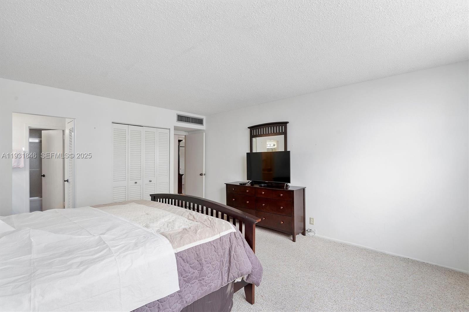 9511 Collins Avenue, Unit 606 Surfside, FL 33154 - Photo 19 of 43 a bedroom with a bed and a flat screen tv