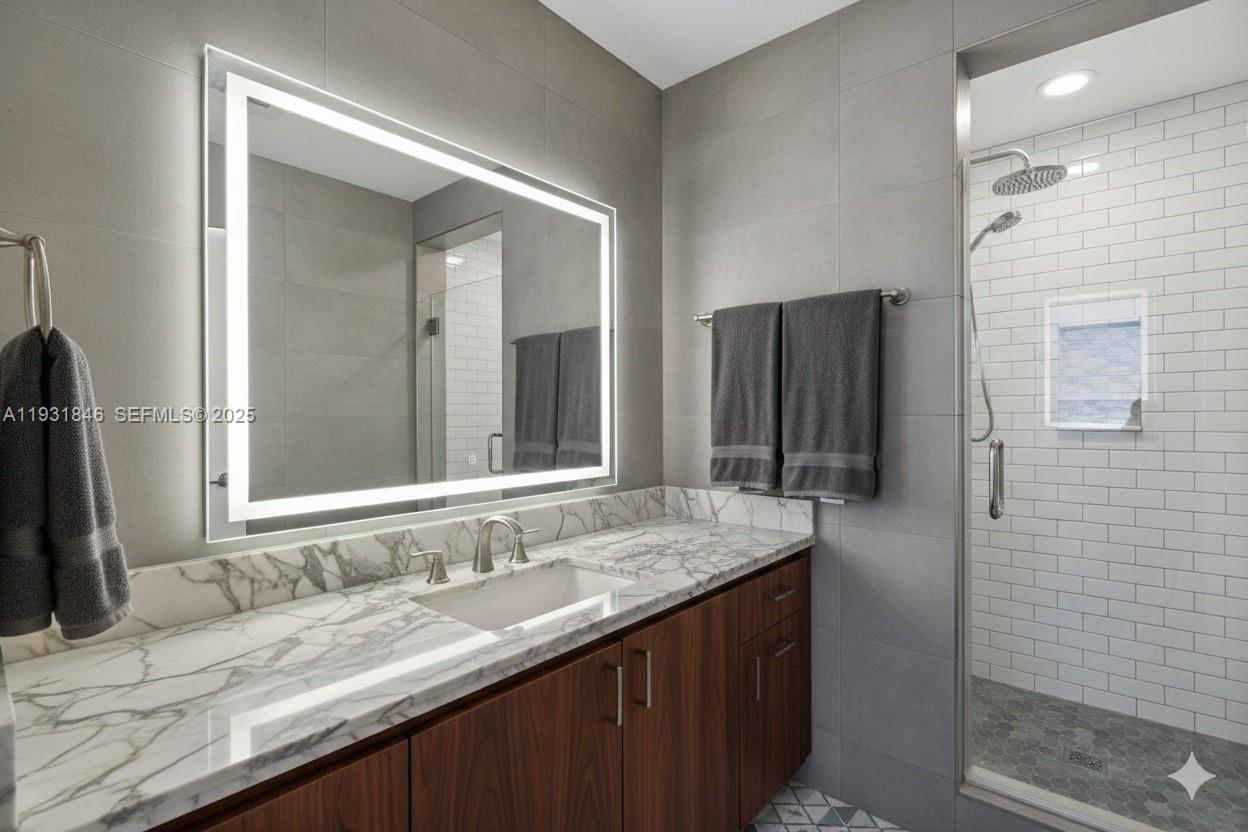 9511 Collins Avenue, Unit 606 Surfside, FL 33154 - Photo 20 of 43 a bathroom with a granite countertop sink and a mirror