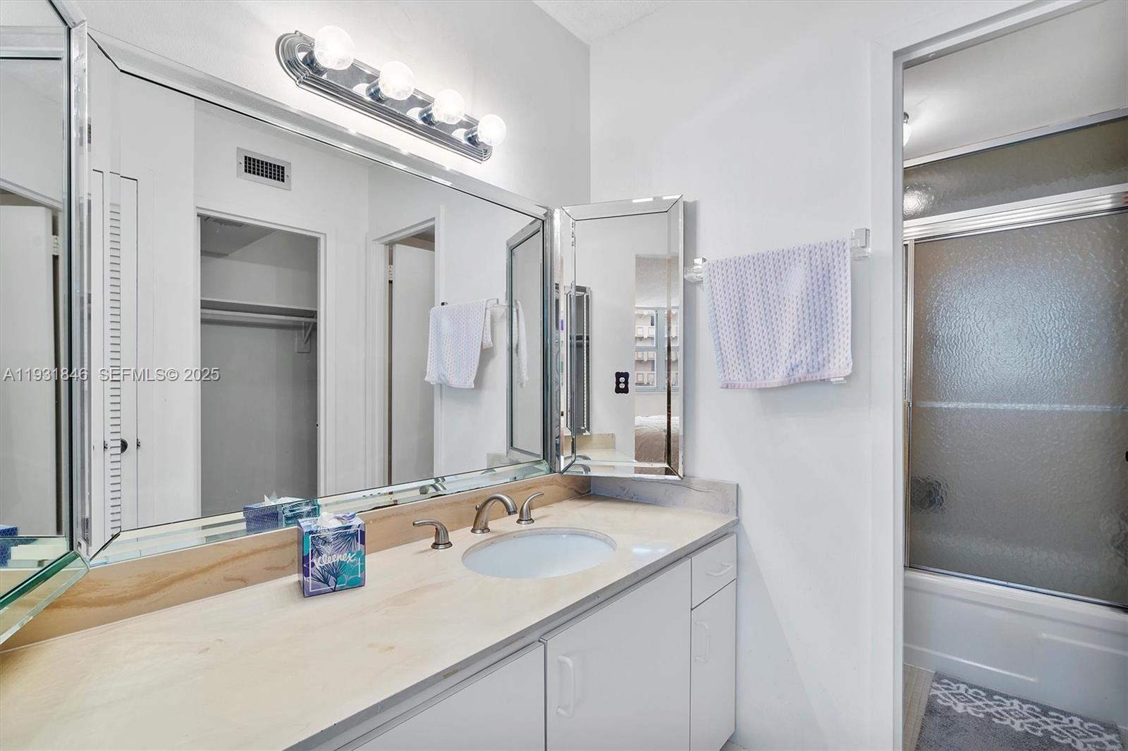 9511 Collins Avenue, Unit 606 Surfside, FL 33154 - Photo 21 of 43 a bathroom with a sink double vanity and a mirror
