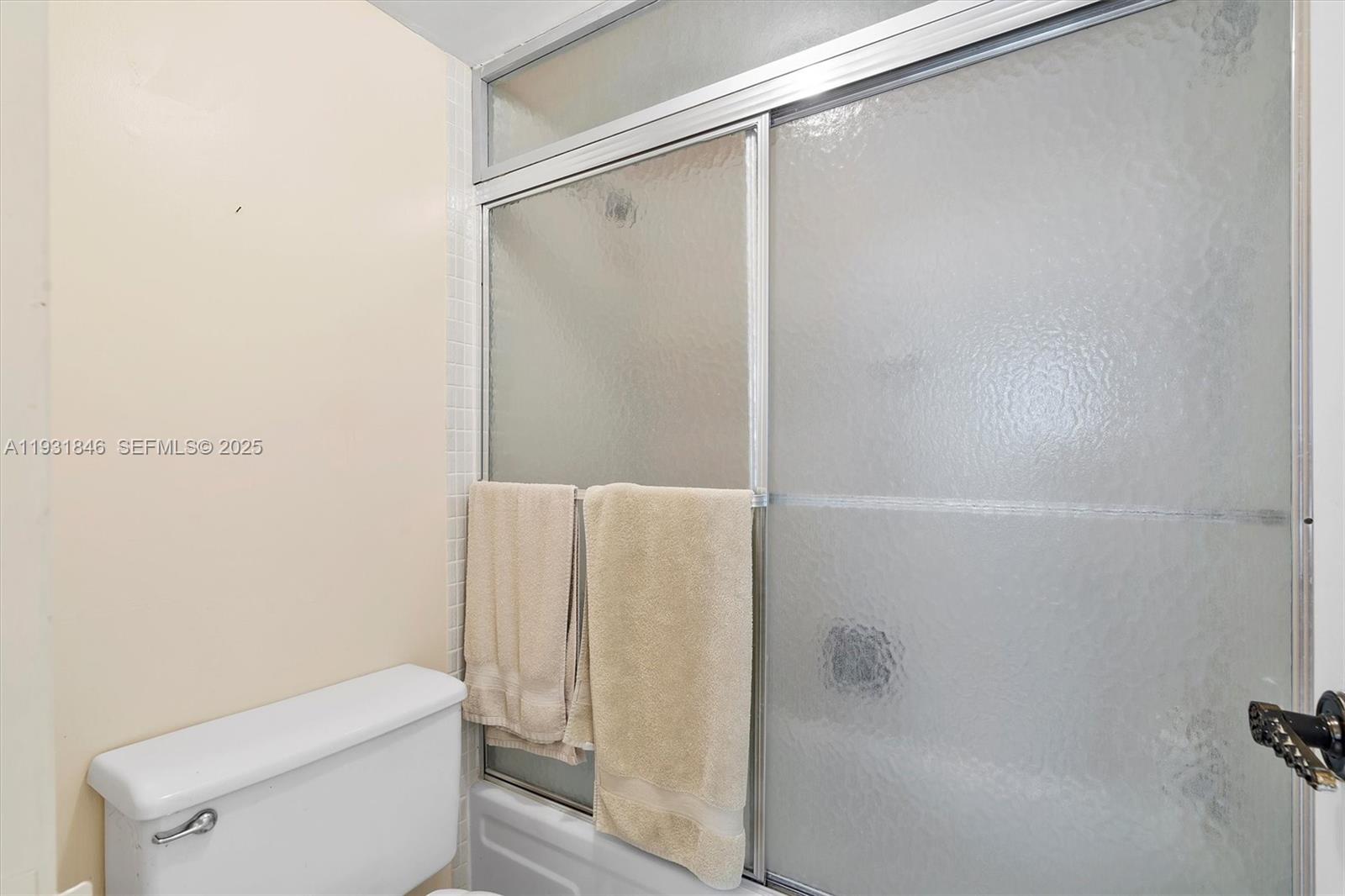 9511 Collins Avenue, Unit 606 Surfside, FL 33154 - Photo 22 of 43 a bathroom with a shower and a toilet