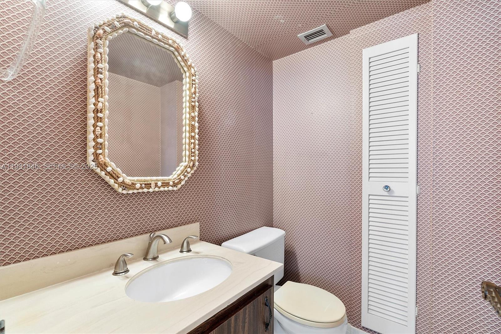 9511 Collins Avenue, Unit 606 Surfside, FL 33154 - Photo 25 of 43 a white toilet sitting next to a bathroom sink