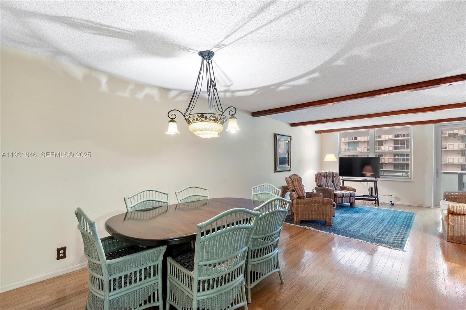 9511 Collins Avenue, Unit 606 Surfside, FL 33154 - Photo 4 of 43 a view of a dining room with furniture wooden floor and chandelier