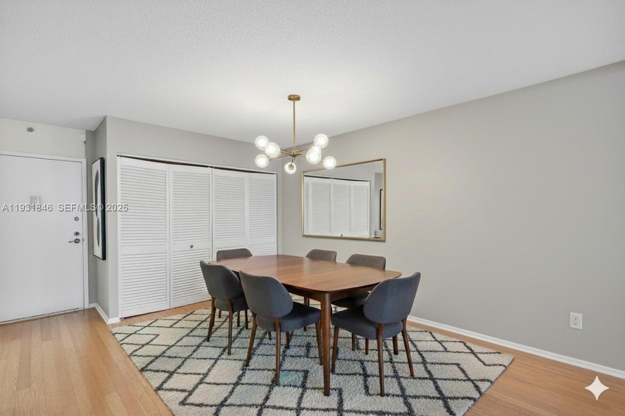9511 Collins Avenue, Unit 606 Surfside, FL 33154 - Photo 9 of 43 a view of a dining room with furniture and chandelier