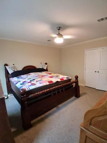 a bed sitting in a bedroom next to a lamp