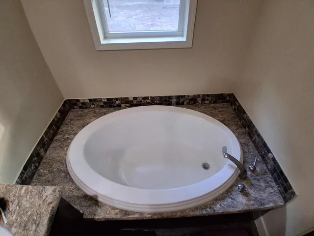 a bathroom with a granite countertop window