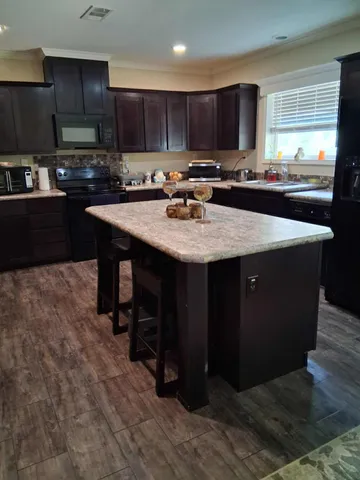 a kitchen with stainless steel appliances granite countertop a sink a stove a refrigerator and a cabinets