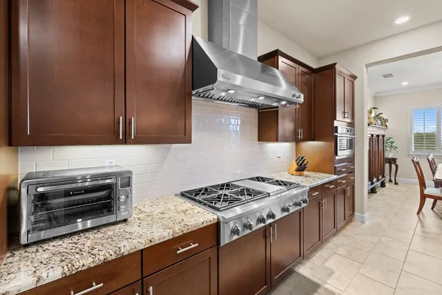 a kitchen with stainless steel appliances granite countertop a stove and a sink