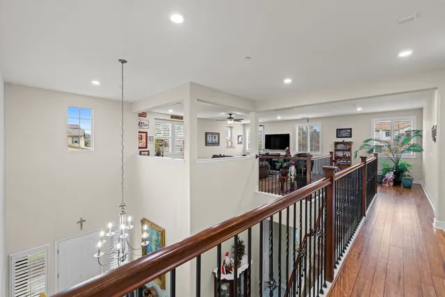 a view of a hallway with wooden floor and furniture